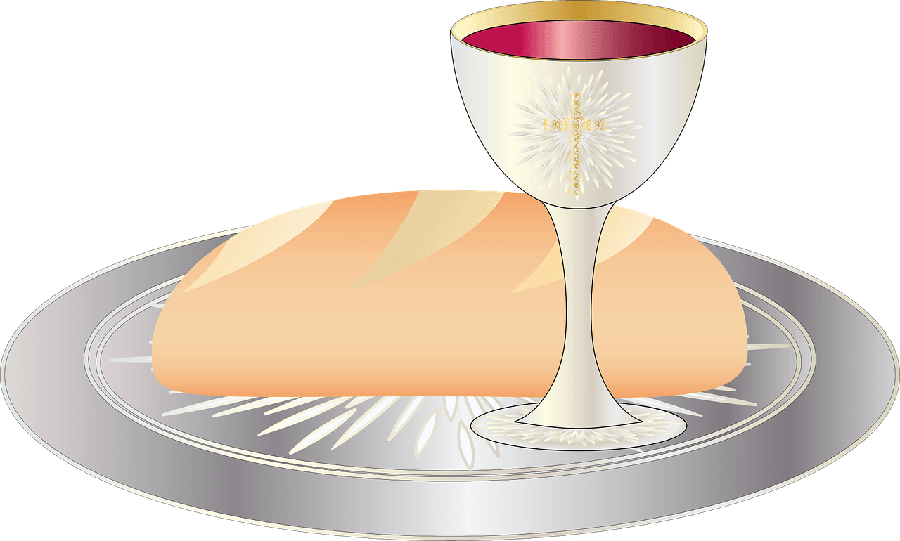 Nattvardskalk med vin och ett bröd på ett fat